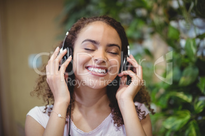 Close-up of female business executive listening music on headphone