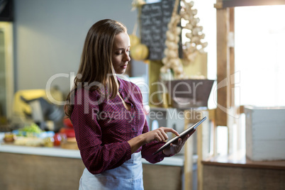 Female staff using digital tablet at counter