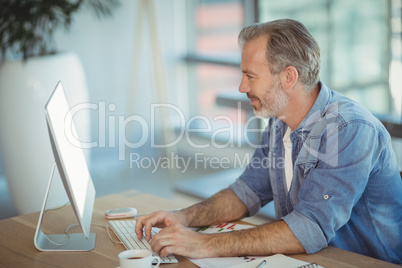 Male executive sitting at desk and working on personal computer