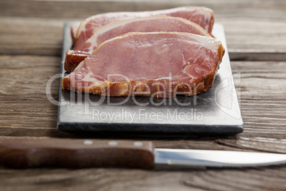 Sirloin chop on black slate plate with knife