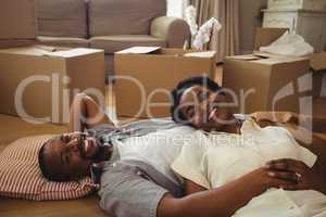 Portrait of smiling couple lying in living room