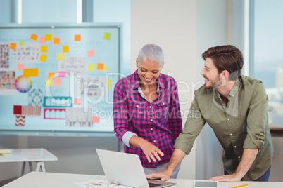 Graphic designers discussing over laptop