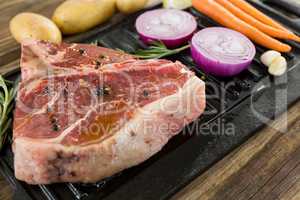 Sirloin chop and ingredients in black box against wooden background