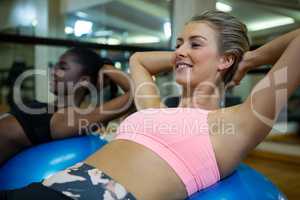 Smiling woman performing pilate on exercise ball