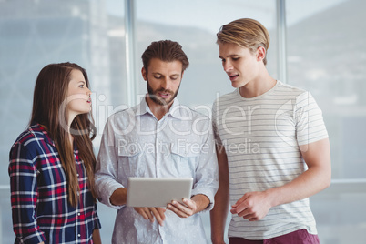 Business executives discussing over digital tablet