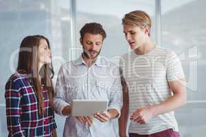 Business executives discussing over digital tablet