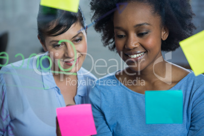 Female graphic designers reading text on the glass