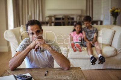 Thoughtful man sitting in living room