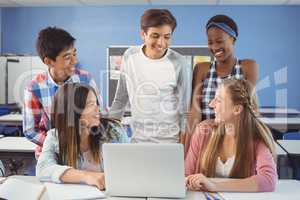 Group of students using laptop in classroom