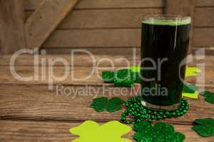 Glass of green beer, beads and shamrock for St Patricks Day