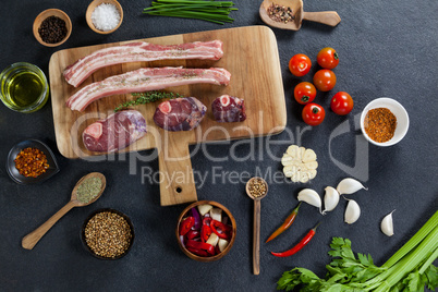 Varieties of meat with spices on wooden board