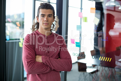 Business executive standing with arms crossed in office