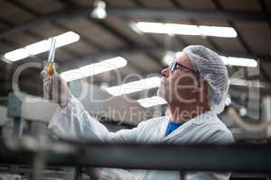 Factory engineers checking a sample of drink