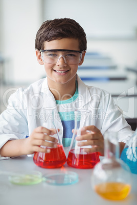 Portrait of schoolboy doing a chemical experiment in laboratory