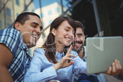 Executives using digital tablet outside office building