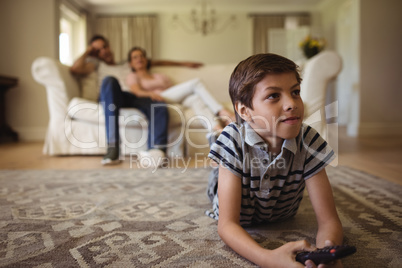 Parents and son watching television in living room