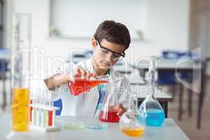 Attentive schoolboy doing a chemical experiment in laboratory