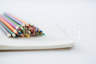 Colored pencils kept on the book