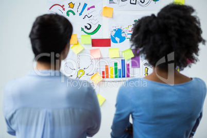 Female graphic designers looking at the white board