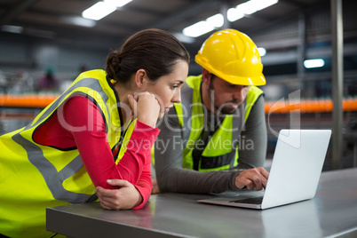 Factory workers using laptop