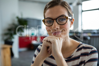 Smiling female graphic designer in spectacles at creative office