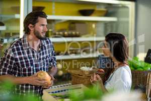 Woman interacting with vendor while buying vegetables