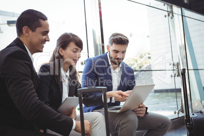 Business executives using laptop on platform