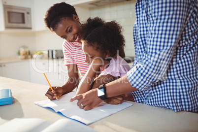 Parents assisting daughter with homework