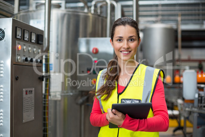 Female factory worker holding digital tablet