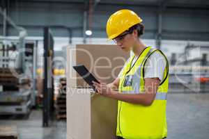 Female factory worker using a digital tablet in factory