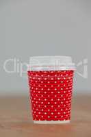 Disposable coffee cup on wooden background