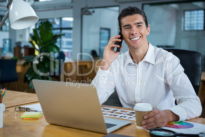 Man talking on mobile phone at desk