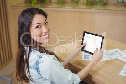 Portrait of female business executive using digital tablet at desk