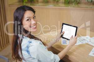 Portrait of female business executive using digital tablet at desk