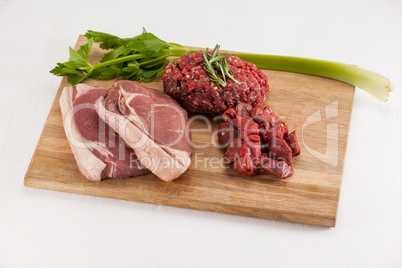 Sirloin chop, beef patty and diced beef on wooden board