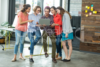 Business executives discussing over laptop