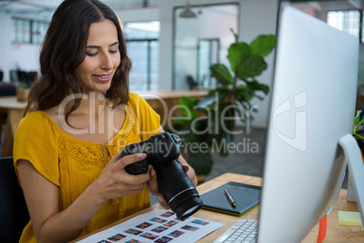 Graphic designer looking at pictures in digital camera