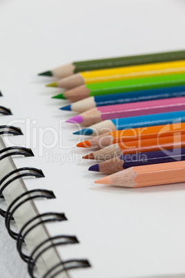 Close-up of colored pencils and notebook