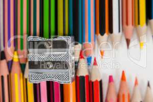 Colored pencils and sharpener on white background