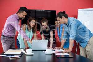 Businesspeople having discussion over laptop in office