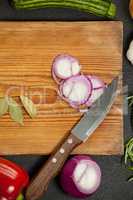 Knife and ingredients on wooden board