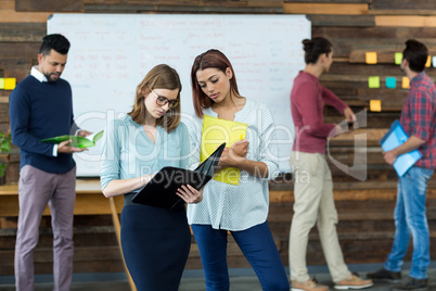 Business executives discussing over file during meeting