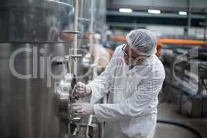 Factory engineer turning control wheel of storage tank