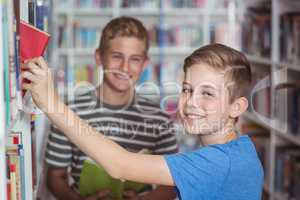 Schoolboys selecting book in library