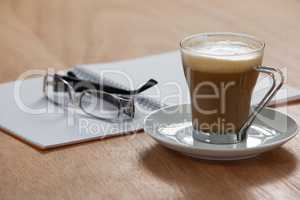 Cup of coffee with spectacles and organizer