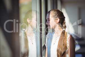 Schoolgirl looking through window in classroom