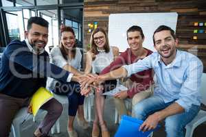 Team of businesspeople forming hand stack in office