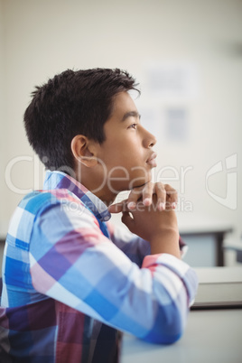 Thoughtful schoolboy sitting in classroom Thoughtful schoolboy sitting in classroom