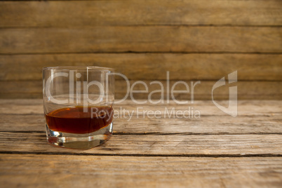 Glass of whisky on wooden table