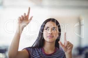 Attentive schoolgirl gesturing in classroom